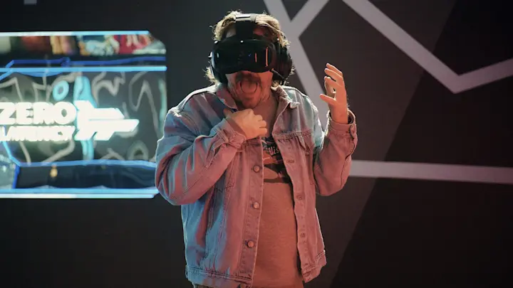 A man wearing a Zero Latency VR headset and denim jacket looking terrified and screaming while playing the Haunted VR experience.